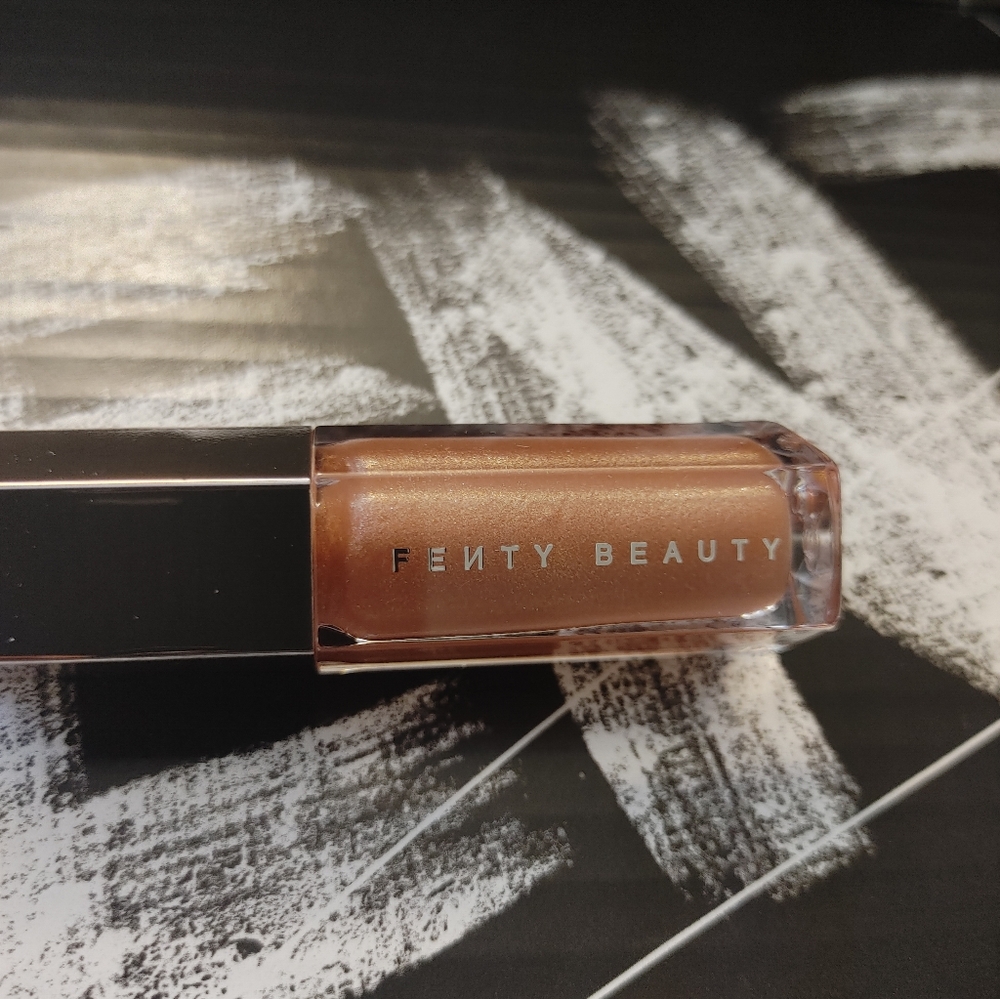 Fenty Beauty-Champ Stamp. Gloss Bomb Universal Lip Luminizer. Gold Pearl Shimmer